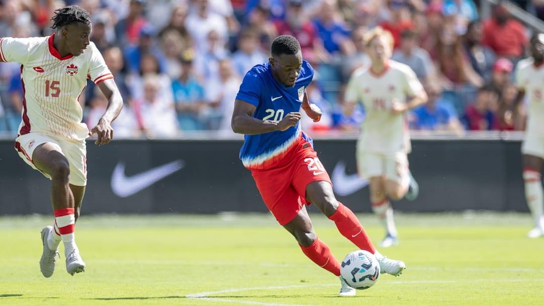 USMNT striker Folarin Balogun dribbles the ball against Canada.