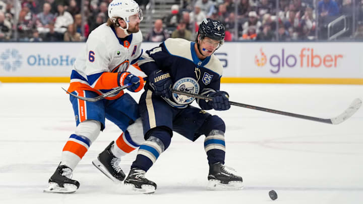 Feb 28, 2026; Columbus, Ohio, USA;  Columbus Blue Jackets center Cole Sillinger (4) skates for the puck against New York Islanders defenseman Ryan Pulock (6) in the second period at Nationwide Arena. Mandatory Credit: Aaron Doster-Imagn Images