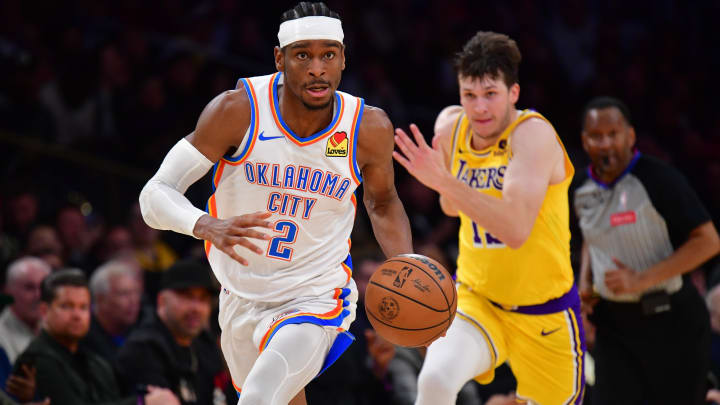 Mar 4, 2024; Los Angeles, California, USA; Oklahoma City Thunder guard Shai Gilgeous-Alexander (2) moves the ball ahead of Los Angeles Lakers guard Austin Reaves (15) during the second half at Crypto.com Arena. Mandatory Credit: Gary A. Vasquez-USA TODAY Sports