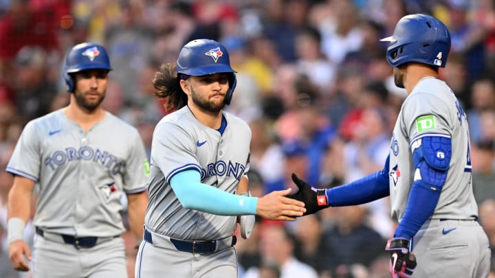 Jun 25, 2024; Boston, Massachusetts, USA; Toronto Blue Jays shortstop Bo Bichette (11) high-fives right fielder George Springer (4) after scoring a run against the Boston Red Sox during the third inning at Fenway Park. Mandatory Credit: Brian Fluharty-USA TODAY Sports