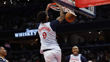 Dec 7, 2024; Washington, District of Columbia, USA; Washington Wizards forward Justin Champagnie (9) dunks the ball as Denver Nuggets forward Peyton Watson (8) and Wizards guard Bub Carrington (8) look on in the fourth quarter at Capital One Arena. Mandatory Credit: Geoff Burke-Imagn Images