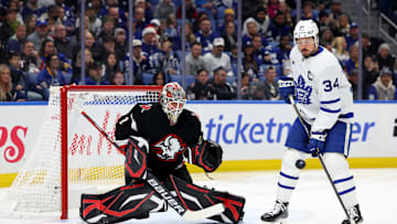 Dec 20, 2024; Buffalo, New York, USA;  Toronto Maple Leafs center Auston Matthews (34) looks to deflect a shot on Buffalo Sabres goaltender Ukko-Pekka Luukkonen (1) during the first period at KeyBank Center. Mandatory Credit: Timothy T. Ludwig-Imagn Images
