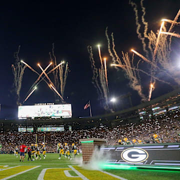 Fireworks are fired off as the Green Bay Packers run out of the tunnel before their game against the Detroit Lions.