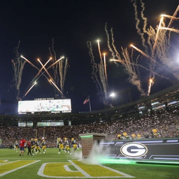 Fireworks are fired off as the Green Bay Packers run out of the tunnel before their football game against the Detroit Lions on Thursday, September 28.