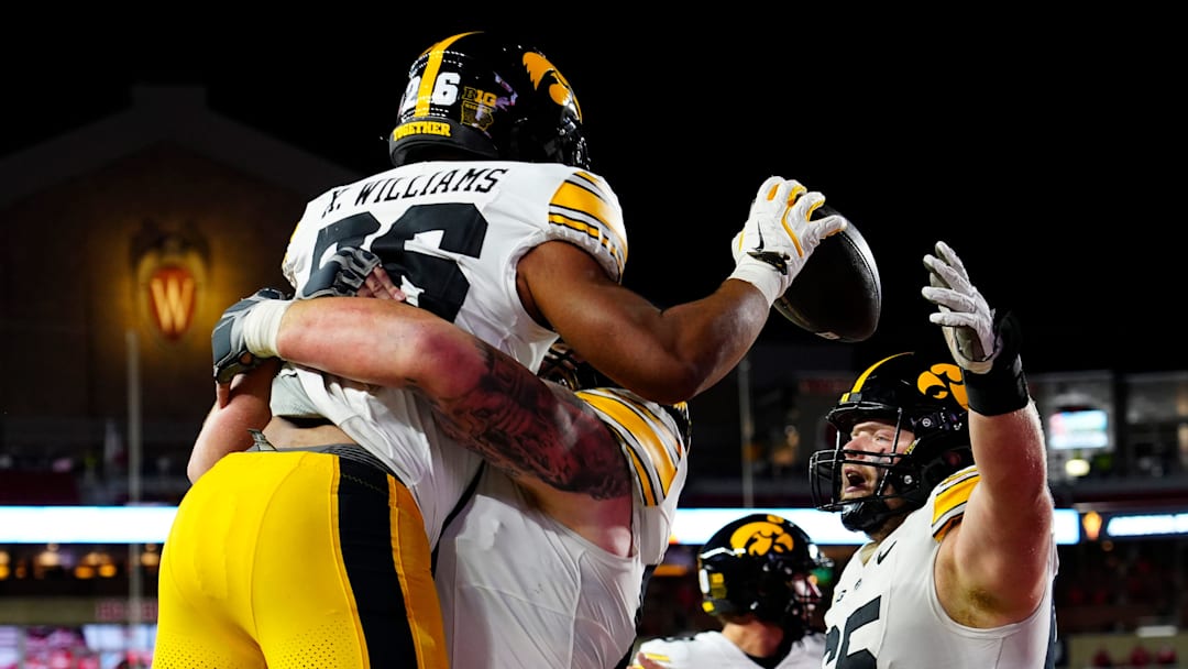 Iowa Hawkeyes offensive lineman Gennings Dunker (67) lifts running back Xavier Williams (26), celebrating the touchdown during the second half of the game against the Wisconsin Badgers on Saturday October 11, 2025 at Camp Randall in Madison, Wisconsin.