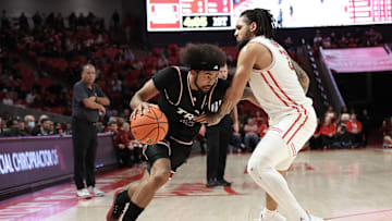 Dec 10, 2024; Houston, Texas, USA; Troy Trojans guard Tayton Conerway (12) drives against Houston Cougars guard Emanuel Sharp (21) in the first half at Fertitta Center. Mandatory Credit: Thomas Shea-Imagn Images