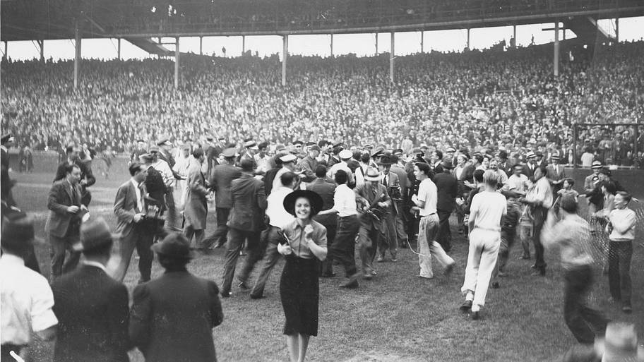A crowd escorts Cubs player Gabby Hartnett across home plate after his walk-off home run to end the 1938 regular season.