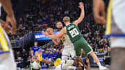 Oct 30, 2025; Milwaukee, Wisconsin, USA; Golden State Warriors guard Stephen Curry (30) looks to pass the ball after Milwaukee Bucks forward Kyle Kuzma (18) fouls forward Draymond Green (23) in the first quarter at Fiserv Forum. Mandatory Credit: Benny Sieu-Imagn Images