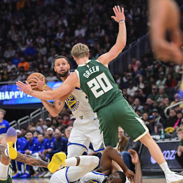 Oct 30, 2025; Milwaukee, Wisconsin, USA; Golden State Warriors guard Stephen Curry (30) looks to pass the ball after Milwaukee Bucks forward Kyle Kuzma (18) fouls forward Draymond Green (23) in the first quarter at Fiserv Forum. Mandatory Credit: Benny Sieu-Imagn Images
