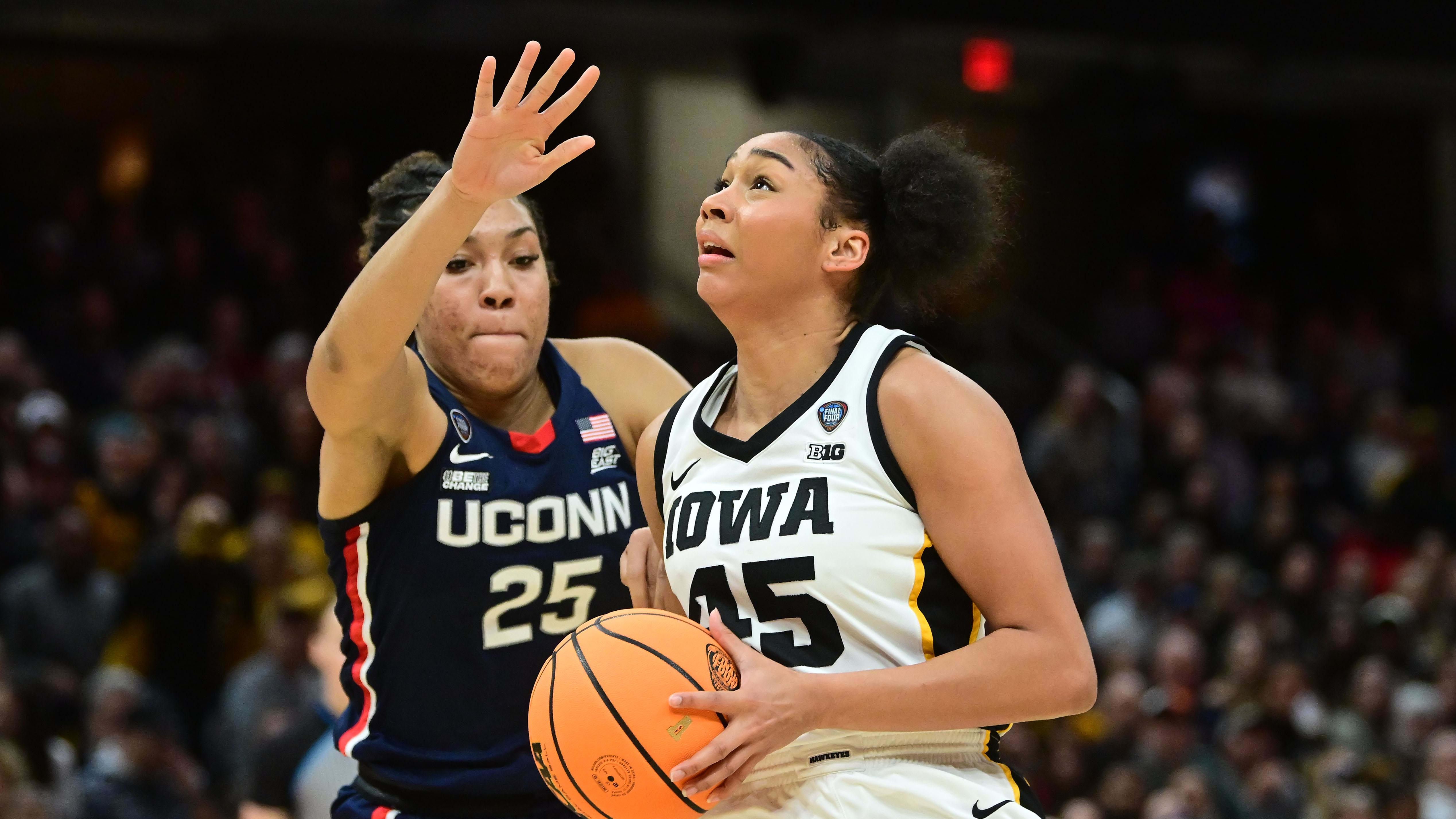 Iowa Hawkeyes forward Hannah Stuelke (45) dribbles the ball against a UConn defender.