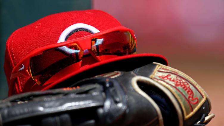 A view of the stadium reflection in the sunglasses on a Cincinnati Reds hat.