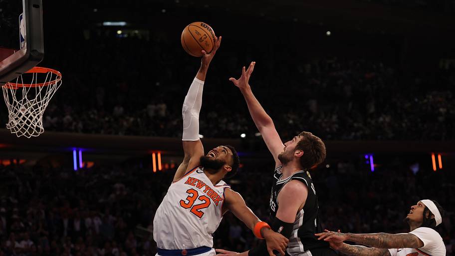 New York Knicks center Karl-Anthony Towns reaches for a rebound in front of San Antonio Spurs center Luke Kornet.