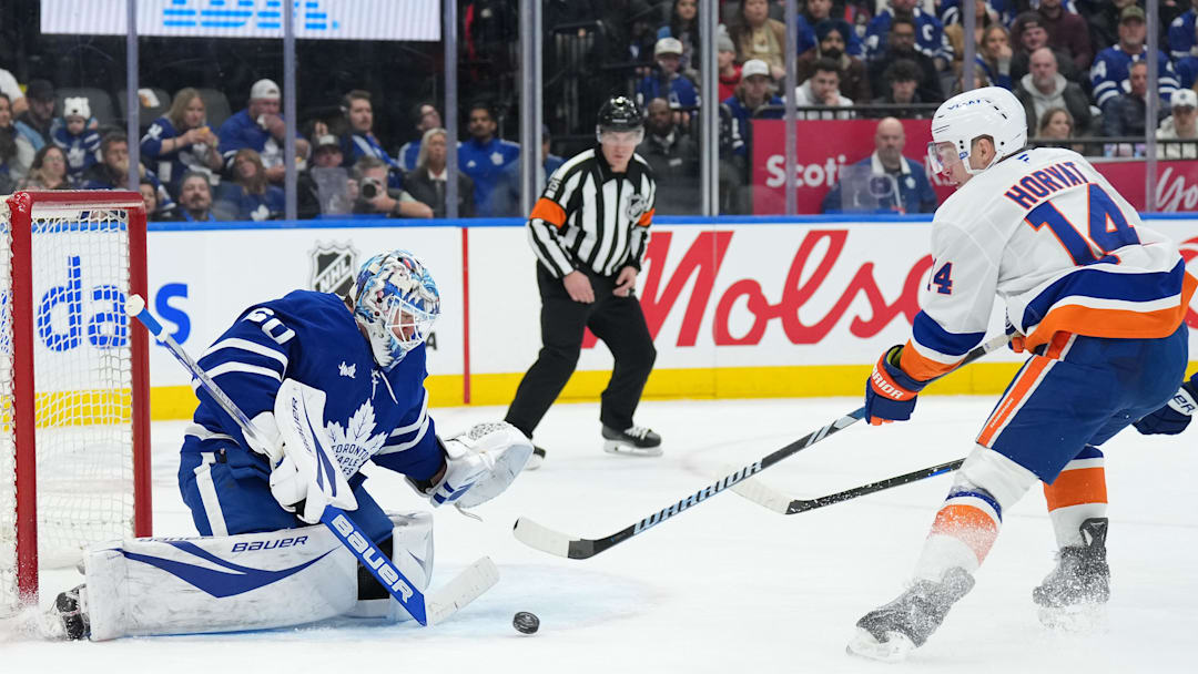Dec 31, 2024; Toronto, Ontario, CAN; New York Islanders center Bo Horvat (14) battles for the puck in front of Toronto Maple Leafs goaltender Joseph Woll (60) during the second period at the Scotiabank Arena. Mandatory Credit: Nick Turchiaro-Imagn Images