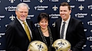 Feb 13, 2025; New Orleans, LA, USA;  New Orleans Saints owner Gayle Benson and general manager Mickey Loomis pose with the new head coach Kellen Moore at Ochsner Sports Performance Center. Mandatory Credit: Stephen Lew-Imagn Images
