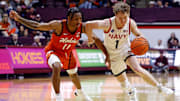 Dec 15, 2024; Blacksburg, Virginia, USA; Navy Midshipmen guard Austin Benigni (1) drives to the basket against Virginia Tech Hokies guard Ben Hammond (11) during the second half at Cassell Coliseum. 