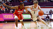 Dec 15, 2024; Blacksburg, Virginia, USA; Navy Midshipmen guard Austin Benigni (1) drives to the basket against Virginia Tech Hokies guard Ben Hammond (11) during the second half at Cassell Coliseum. 