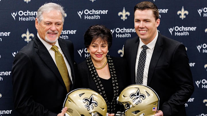 Feb 13, 2025; New Orleans, LA, USA; New Orleans Saints owner Gayle Benson and general manager Mickey Loomis pose with the new head coach Kellen Moore at Ochsner Sports Performance Center. Mandatory Credit: Stephen Lew-Imagn Images Feb 13, 2025; New Orleans, LA, USA; New Orleans Saints owner Gayle Benson and general manager Mickey Loomis pose with the new head coach Kellen Moore at Ochsner Sports Performance Center. Mandatory Credit: Stephen Lew-Imagn Images