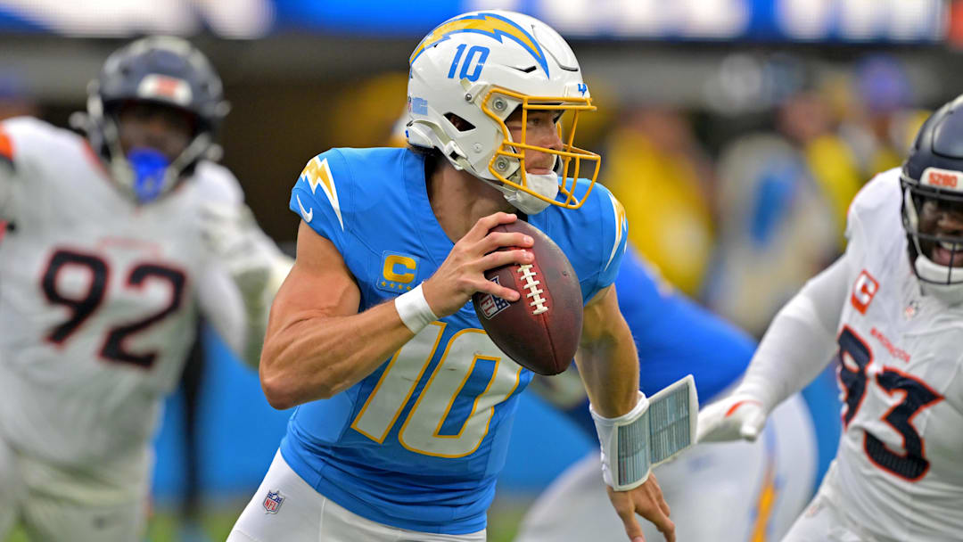 Sep 21, 2025; Inglewood, California, USA;  Los Angeles Chargers quarterback Justin Herbert (10) avoids Denver Broncos defensive tackle DJ. Jones (93) as he looks to pass in the first half at SoFi Stadium. 