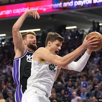 Mar 31, 2024; Sacramento, California, USA; Utah Jazz center Walker Kessler (right) rebounds against Sacramento Kings forward Domantas Sabonis (left) during the first quarter at Golden 1 Center. Mandatory Credit: Darren Yamashita-Imagn Images