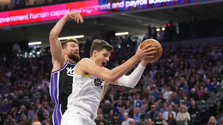 Mar 31, 2024; Sacramento, California, USA; Utah Jazz center Walker Kessler (right) rebounds against Sacramento Kings forward Domantas Sabonis (left) during the first quarter at Golden 1 Center. Mandatory Credit: Darren Yamashita-Imagn Images