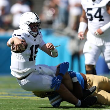 Penn State quarterback Drew Allar is tackled by UCLA linebacker Jonjon Vaughns.