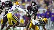 Oct 25, 2025; Baton Rouge, Louisiana, USA; Texas A&M Aggies running back Rueben Owens II (4) runs against Louisiana State Tigers cornerback Mansoor Delane (4) and defensive end Jack Pyburn (44) during the second half at Tiger Stadium. Mandatory Credit: Stephen Lew-Imagn Images