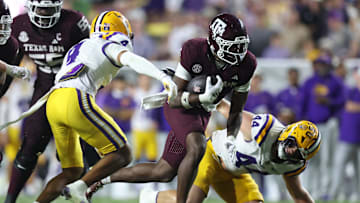 Oct 25, 2025; Baton Rouge, Louisiana, USA; Texas A&M Aggies running back Rueben Owens II (4) runs against Louisiana State Tigers cornerback Mansoor Delane (4) and defensive end Jack Pyburn (44) during the second half at Tiger Stadium. Mandatory Credit: Stephen Lew-Imagn Images