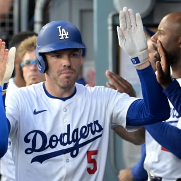 Aug 9, 2024; Los Angeles, California, USA; Los Angeles Dodgers first baseman Freddie Freeman (5) is congratulated in the dugout after a solo home run in the first inning against the Pittsburgh Pirates at Dodger Stadium. Mandatory Credit: Jayne Kamin-Oncea-USA TODAY Sports