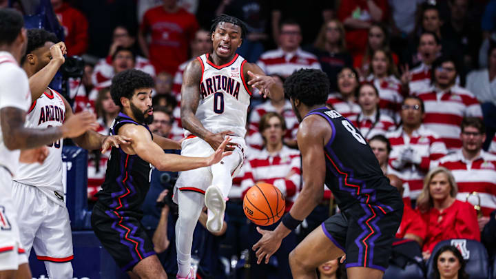 Dec 30, 2024; Tucson, Arizona, USA; Arizona Wildcats guard Jaden Bradley (0) loses control over the ball as TCU Horned Frogs guard Noah Reynolds (21) and TCU Horned Frogs center Ernest Udeh Jr. (8) attempt to grab the ball during the first half of the game at McKale Center. Mandatory Credit: Aryanna Frank-Imagn Images
