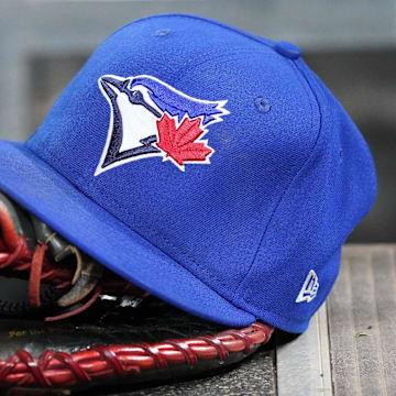 Apr 16, 2025; Toronto, Ontario, CAN; A Toronto Blue Jays hat and glove in the dugout during a game against the Atlanta Braves at Rogers Centre. 