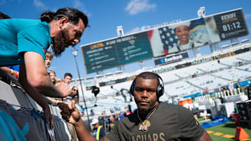 Jacksonville Jaguars defensive end Travon Walker (44) signs autographs before an NFL football game at EverBank Stadium, Sunday, November 16, 2025, in Jacksonville, Fla. 