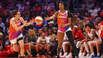 Team WNBA forward Angel Reese (5) passes the ball to Team WNBA guard Caitlin Clark.