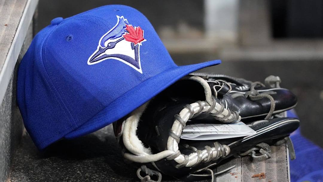 Apr 16, 2025; Toronto, Ontario, CAN; A Toronto Blue Jays hat and glove in the dugout during a game against the Atlanta Braves at Rogers Centre. 