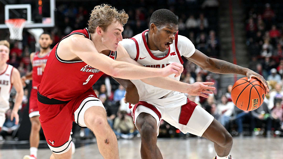 Nov 21, 2024; Spokane, Washington, USA; Washington State Cougars guard Cedric Coward (0) controls the ball against Eastern Washington Eagles guard Andrew Cook (9) in the first half at Spokane Veterans Memorial Arena. Mandatory Credit: James Snook-Imagn Images