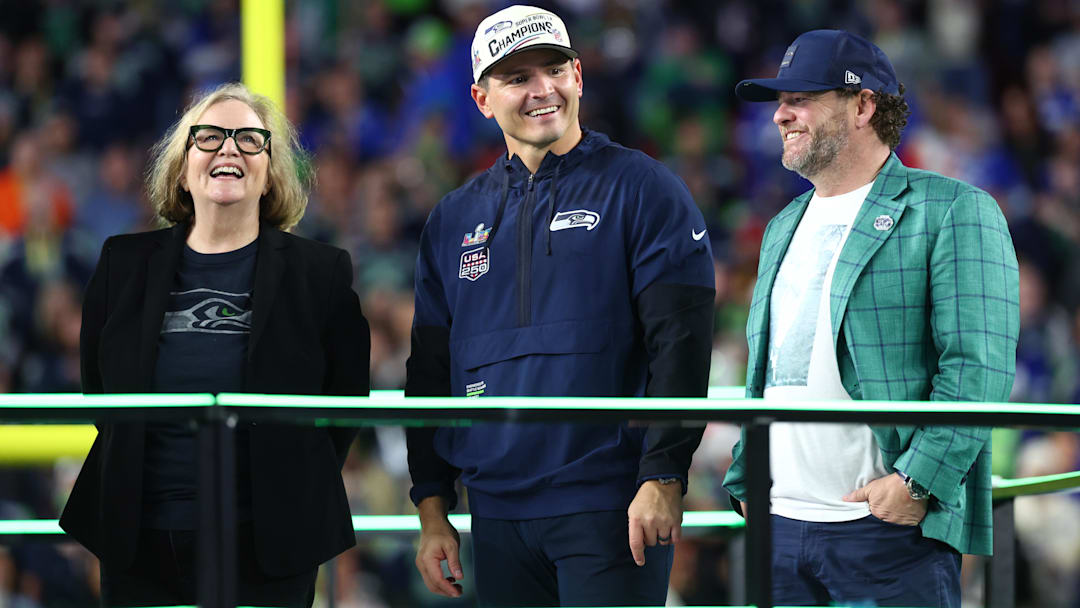Seattle Seahawks chairman Jody Allen, head coach Mike MacDonald, and general manager John Schneider on the podium.