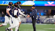 Dec 6, 2025; Charlotte, NC, USA; Virginia Cavaliers head coach Tony Elliott greets players during the second half against the Duke Blue Devils during the 2025 ACC Championship game at Bank of America Stadium. Mandatory Credit: Jim Dedmon-Imagn Images