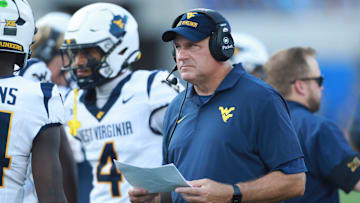 West Virginia Mountaineers head coach Rich Rodriguez looks at plays during the first half of the game against Kansas Jayhawks at David Booth Kansas Memorial Stadium on Sept. 20, 2025.