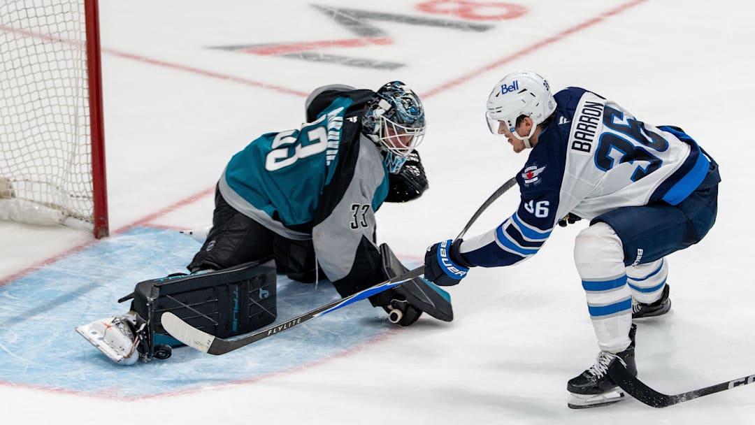 March 1, 2026; San Jose, California, USA; San Jose Sharks goaltender Alex Nedeljkovic (33) blocks the shot of Winnipeg Jets center Morgan Barron (36) during the third period at SAP Center at San Jose. Mandatory Credit: Neville E. Guard-Imagn Images
