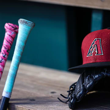 Jun 7, 2023; Washington, District of Columbia, USA; A general view of an Arizona Diamondbacks hat, glove, and bats in the dugout during the fifth inning of the game against the Washington Nationals at Nationals Park. Mandatory Credit: Scott Taetsch-Imagn Images