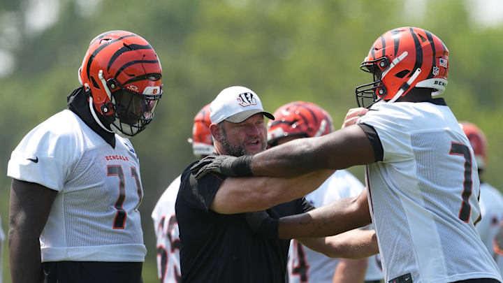 Jun 10, 2025; Cincinnati, OH, USA; Cincinnati Bengals offensive line coach Scott Peters (center) works with offensive tackle Amarius Mims (71) (left) and offensive tackle Caleb Etienne (77) )(right) during practice at Paycor Stadium. Mandatory Credit: Kareem Elgazzar-Imagn Images