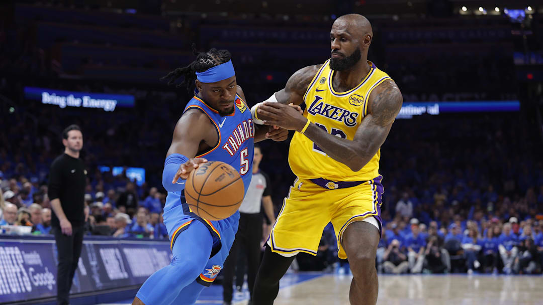 Thunder guard Luguentz Dort drives around Lakers forward LeBron James.