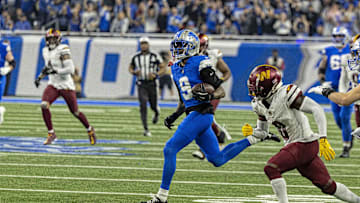Jan 18, 2025; Detroit, Michigan, USA;  Detroit Lions wide receiver Jameson Williams (9) carries the ball against Washington Commanders corner back Mike Sainristil (0) during the second quarter at Ford Field. Mandatory Credit: David Reginek-Imagn Images