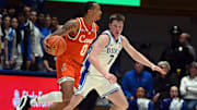 Jan 14, 2025; Durham, North Carolina, USA; Miami Hurricanes guard Matthew Cleveland (0) drives to the basket as Duke Blue Devils forward Kon Knueppel (7) defends during the second half at Cameron Indoor Stadium. Mandatory Credit: Rob Kinnan-Imagn Images
