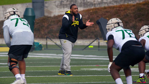 New offensive line coach A'lique Terry, center, runs a drill during the first practice of spring for Oregon football Thursday