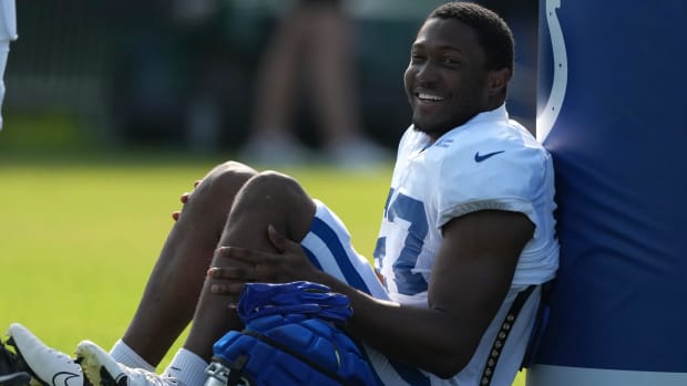 Colts linebacker Jaylon Carlies (white jersey with blue trim) takes a break while sitting during training camp practice. 