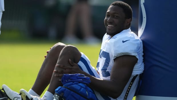 Indianapolis Colts linebacker Jaylon Carlies (white jersey) sits for a break during practice in front of a blue cushion. 