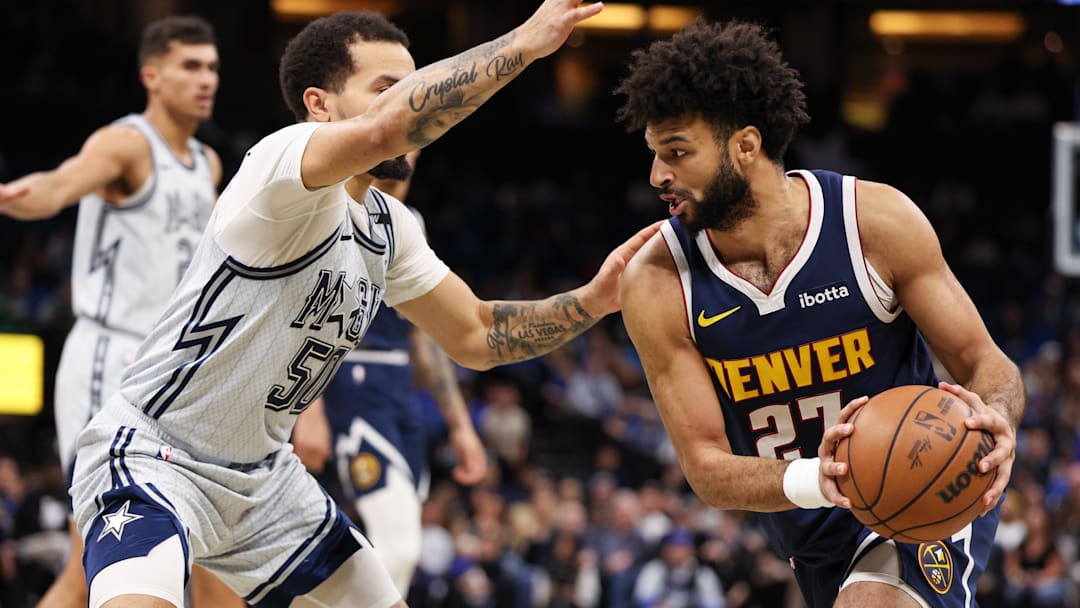 Jan 19, 2025; Orlando, Florida, USA; Denver Nuggets guard Jamal Murray (27) drives to the basket past Orlando Magic guard Cole Anthony (50) in the first quarter at Kia Center. Mandatory Credit: Nathan Ray Seebeck-Imagn Images