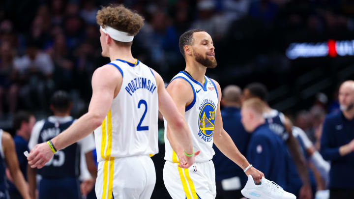 Golden State Warriors guard Stephen Curry (30) reacts with Golden State Warriors guard Brandin Podziemski (2) after losing his shoe during the first half against the Dallas Mavericks at American Airlines Center. Mandatory Credit: