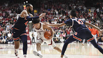 Jan 24, 2024; Tuscaloosa, Alabama, USA;  Auburn Tigers center Johni Broome (4) and forward Chad Baker-Mazara (10) defend as Alabama Crimson Tide guard Mark Sears (1) attempts to drive into the lane at Coleman Coliseum. Mandatory Credit: Gary Cosby Jr.-Imagn Images