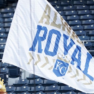 Aug 6, 2020; Kansas City, Missouri, USA; The Kansas City Royals mascot Sluggerrr waves an Always Royal flag in empty stands before the game against the Chicago Cubs at Kauffman Stadium. Mandatory Credit: Denny Medley-Imagn Images